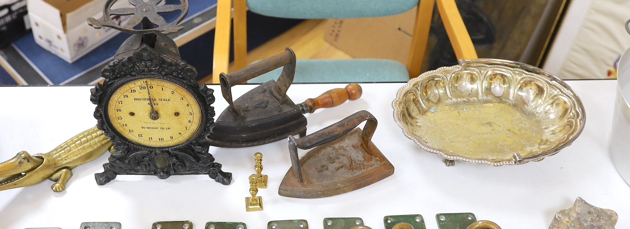 A group of assorted metalwares including plated wares, irons, scales, miniature candlesticks etc.